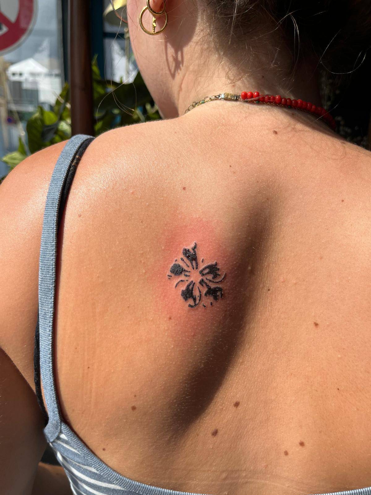 Tatouage hibiscus stamp minimaliste dos